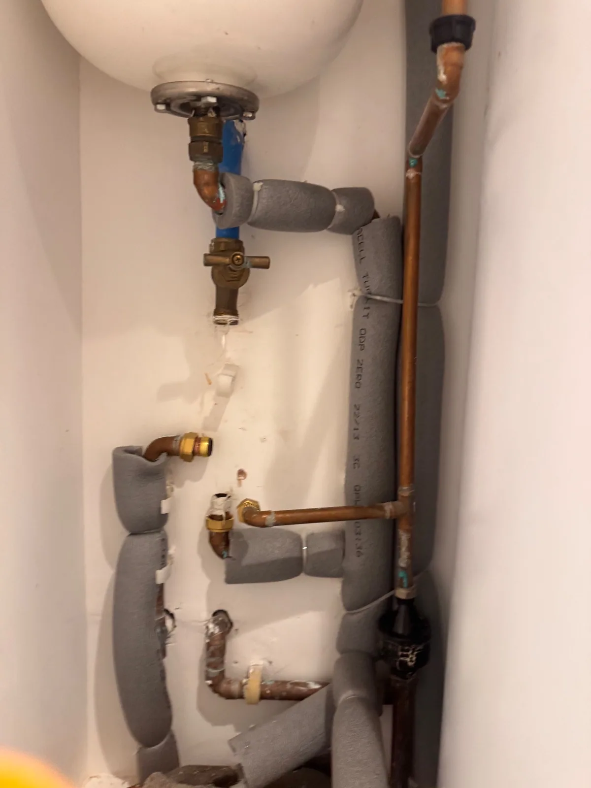 Insulated pipework and valves beneath an unvented hot water cylinder in a London property